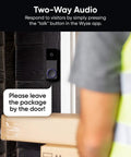 Wireless Duo Cam Video Doorbell With Chime Included, installed beside a door, showing delivery person and package