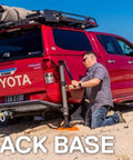 Beefy Heavy Duty Jack Base For Off Road Jacks, 15,400 Lb Load Capacity in use on sandy beach with red truck and man