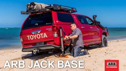 Beefy Heavy Duty Jack Base For Off Road Jacks, 15,400 Lb Load Capacity in use on sandy beach with red truck and man