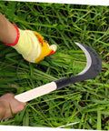 Gloved hand using Long Handle Hand Scythe For Weed Removal And Grass Control Manganese Steel Weeding Tool in garden