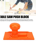 Table Saw Push Block With Comfortable Grip And High Visibility For Woodworking Pro Grade Non Slip Design Easy Install Durable ABS Plastic Push Block For Precise Cuts And Safe Handling, orange with rounded handle, placed on a workbench.