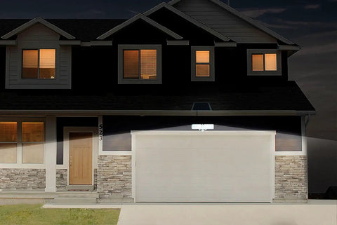 Solar Powered AI Smart Motion Dual Head LED Flood Light 10W 1200 Lumens illuminating garage at night, dusk-to-dawn