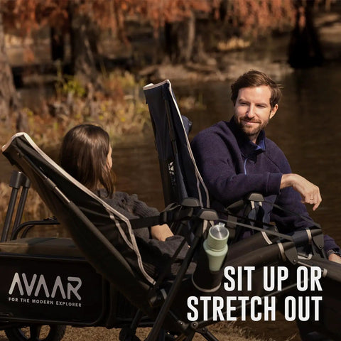 Two people relaxing by the water in a Go Horizon Hammock Chair For Adults Up To 400 Lbs, Lie Flat Folding Camping Chair With Footrest, Black.