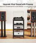 Turntable setup with speakers on stands, black audio rack with amplifier, room setting