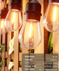 Close-up of 105 Ft Outdoor String Lights With 1W Dimmable S14 Bulbs on wooden panel, displaying warm white glow.