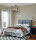 Antique Bronze 3-Light Sphere Pendant Light With Pivoting Armillary Rings over a bed in modern bedroom setting.