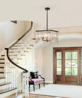 Four Light Crystal Chandelier With Black Iron Frame And K9 Clear Crystals in elegant entryway with staircase and bench.