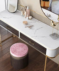 Vanity table with white marble countertop contact paper, featuring a pink stool and cosmetics, on wooden floor.