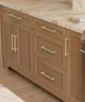 Brushed Gold Cabinet Pulls 5 Inch Zinc Alloy Handles Set of 10 on wooden kitchen cabinets and drawers, side view