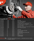 Front view of a mechanic in red uniform inspecting a car's front disc brake rotor and caliper.