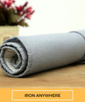 Rolled Portable Ironing Mat 21x28 Inch with Heat Reflective Silicone Coating, shown on a wooden surface.