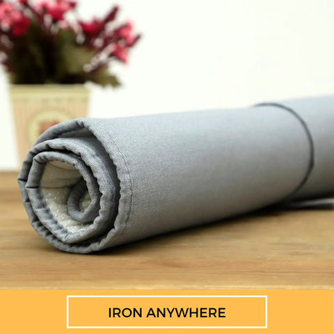 Rolled Portable Ironing Mat 21x28 Inch with Heat Reflective Silicone Coating, shown on a wooden surface.