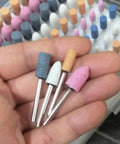 Hand holding Assorted 100 Piece Grinding Stones Set With One Eighth Inch Shank For Rotary Tools Aluminum Oxide Mounted Grinding Bits