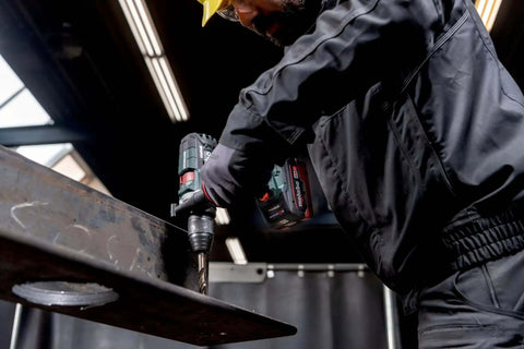 User operating Tough As Nails 18V Cordless Power Drill With Supra SK Drill Chucks on a steel beam in a workshop.