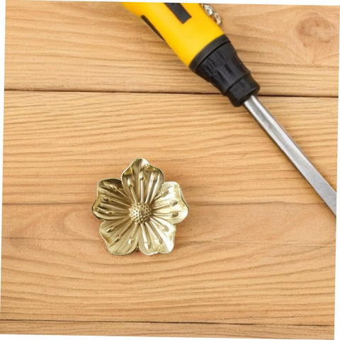 Vintage Brass Flower Cabinet Handle Single Hole Drawer Pull For Wardrobe And Cupboard Doors on wooden surface with screwdriver