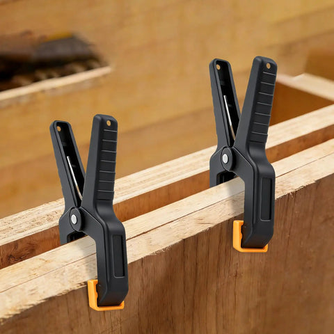 50 Pack Heavy Duty Spring Clamps Set For Woodworking And Multi Use Clips For Balloon Arches Tarp Backdrops And Hanging Items Durable Nylon Body With Steel Springs Two Color Options, black and orange clamps on wood