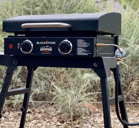 Blackstone tabletop griddle with Propane Adapter Hose And Regulator Conversion Kit 1Lb To 20Lb connected outdoors.