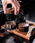 Top Shelf Wood Tamper For Espresso Makers Featuring Spring Loaded Calibration For 51mm 54mm And 58mm Portafilters in use on a wooden barista station.