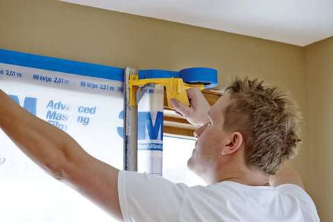 Person using Hand Masker Painter Tape And Masking Film Dispenser Kit For Fast Masking Prep With A 12 Inch Blade And Surface Safe Tape Film Set