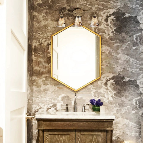 Vintage Vanity Light Fixture Rustic Bathroom Wall Sconce Three Light With Amber Glass Shade above mirror in cozy bathroom.