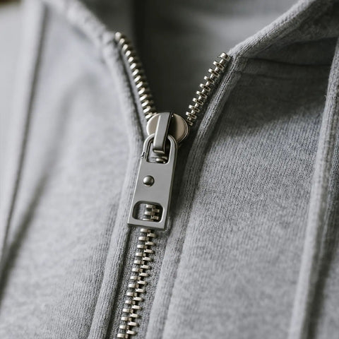Close-up of a jacket with a metal zipper, showing Eleven Pieces Zipper Pull Replacement Set Heavy Duty Metal Zipper Repair Kit Detachable Pull Tabs