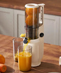 Aynefy 200W Cold Press Juicer With Wide Feed Chute For Whole Fruits extracting fresh orange juice into glasses on kitchen counter.