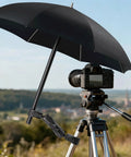 Camera on tripod with Double Clamp Umbrella Camera Pole with 360 Degree Ball Head, set up outdoors.
