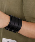 Fresh Hip Hop Drip Wide PU Leather Cuffs For Men Adjustable Punk Rock Gothic Wrists Band Pair Black on wrist with casual shirt