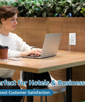 Woman using laptop at a cafe with a 20 Pack White USB Wall Outlet With Dual Type A C Quick Charge Ports 15 Amp Tamper Resistant Faceplate.