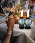 Four Pack Glass Table Torches With Citronella For Outdoor Patio And Garden on a dinner table, lit, with crystal gem design.