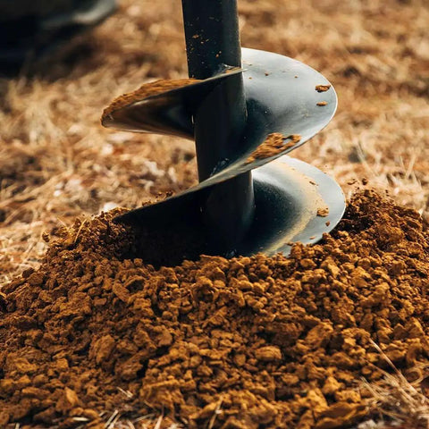 Close-up of 9 Inch Auger Bit For 3 Point Post Hole Digger With Fishtail Point HD Steel in soil, showcasing drilling action.