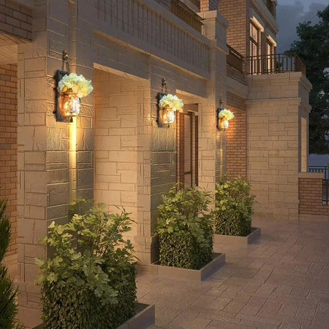 Outdoor view with lit Rustic Mason Jar Wall Lights With Remote, Battery Powered Sconce Set Of 2 on brick wall.
