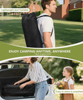 Man carrying 4Ft Folding Camping Table With Carry Bag And Mesh Storage, showing portability feature in a scenic outdoor setting.