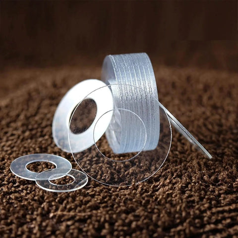 Stack of transparent PVC hard washers in various sizes from M1.2 to M20 for screw insulation and vibration isolation applications.