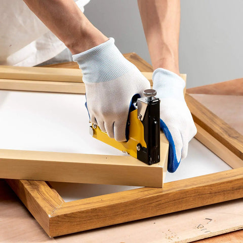 Heavy Duty 4 In 1 Staple Gun With 6000 Staples Remover Gloves And Manual Brad Nailer Adjustable Power For Wood Upholstery Carpentry And DIY Projects Kit being used on a wooden frame