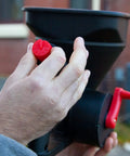 Man adjusting flow on Five Pound All Season Handheld Spreader With Easy Fill Design For Seed Ice Melt And Fertilizer Perfect For Sidewalks Yards