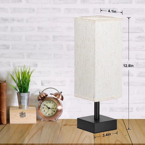 Small Table Lamp For Bedroom And Nightstand With Square Fabric Shade on wooden desk near clock and plant, minimalist design.