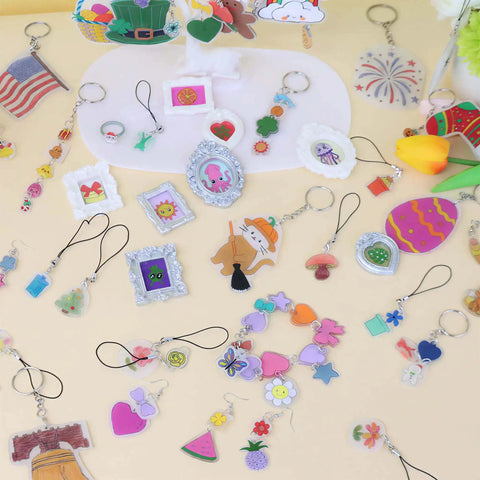 Colorful keychains and charms from 161 Piece Shrink Plastic Keychain Making Kit With 30 Sheets, Includes Hole Punch, 20 Lobster Clasps, 100 Jump Rings, 10 Lanyards for creative crafters.