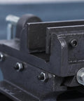 Close-up of 5 Inch Cross Slide Bench Vise With Smooth Moving Handles Cast Iron Construction secure clamping jaws on workbench.