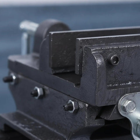 Close-up of 5 Inch Cross Slide Bench Vise With Smooth Moving Handles Cast Iron Construction secure clamping jaws on workbench.