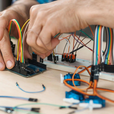 Person assembling circuit with Solderless Breadboard Jumper Wires Kit For Electronics Prototyping With 400 And 830 Tie Point Boards