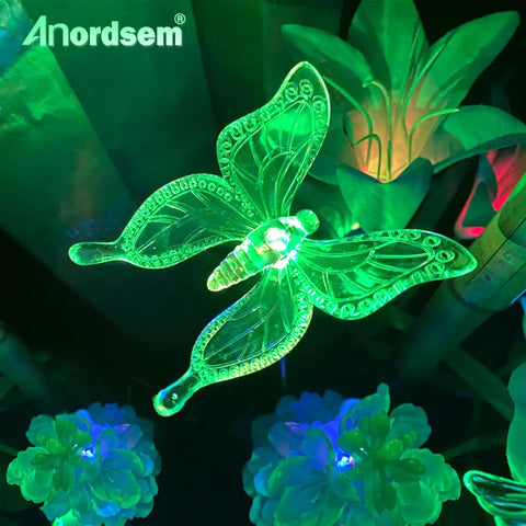 Solar Garden Lights Outdoor Set Of 6 Insect Stake Lights with green LED butterfly in garden at night, colorful atmosphere.