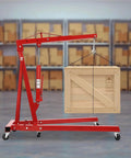 Professional Grade Heavy Duty Two Ton Hydraulic Engine Hoist Folding Cherry Picker Shop Crane lifting a wooden crate in garage.