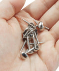 Sweet Mini Silver Upholstery Tacks 100 Piece Set For Furniture Makeovers And Craft Fixes Featuring Threaded Legs in a hand.