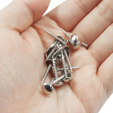 Sweet Mini Silver Upholstery Tacks 100 Piece Set For Furniture Makeovers And Craft Fixes Featuring Threaded Legs in a hand.