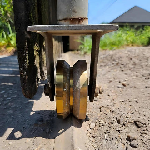 Smooth Operator 4 Inch Crowned V Groove Sliding Gate Rollers Double Bearing Wheels with U Bracket on track close-up.