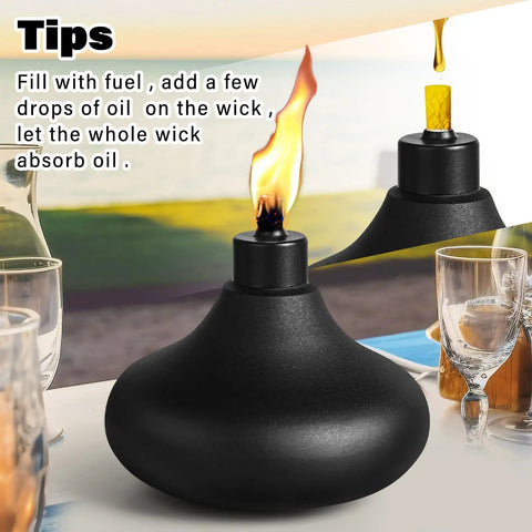 Close-up of a single black metal table top torch with flame, part of a Two Pack Metal Table Top Torches With 24.5 Ounce Citronella Fuel Capacity