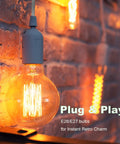 Close-up of illuminated E26/E27 bulb in a hanging light socket with cord extension kit 8.2 ft on a brick wall, warm glow