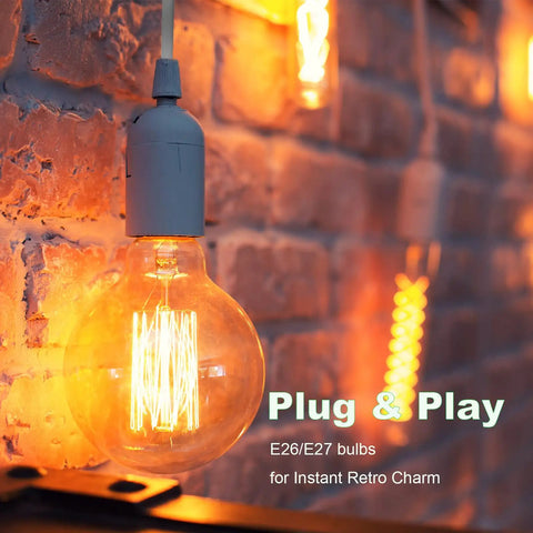 Close-up of illuminated E26/E27 bulb in a hanging light socket with cord extension kit 8.2 ft on a brick wall, warm glow