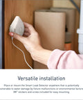 Person installing Flo Smart Water Leak Detector on wooden surface for basement monitoring